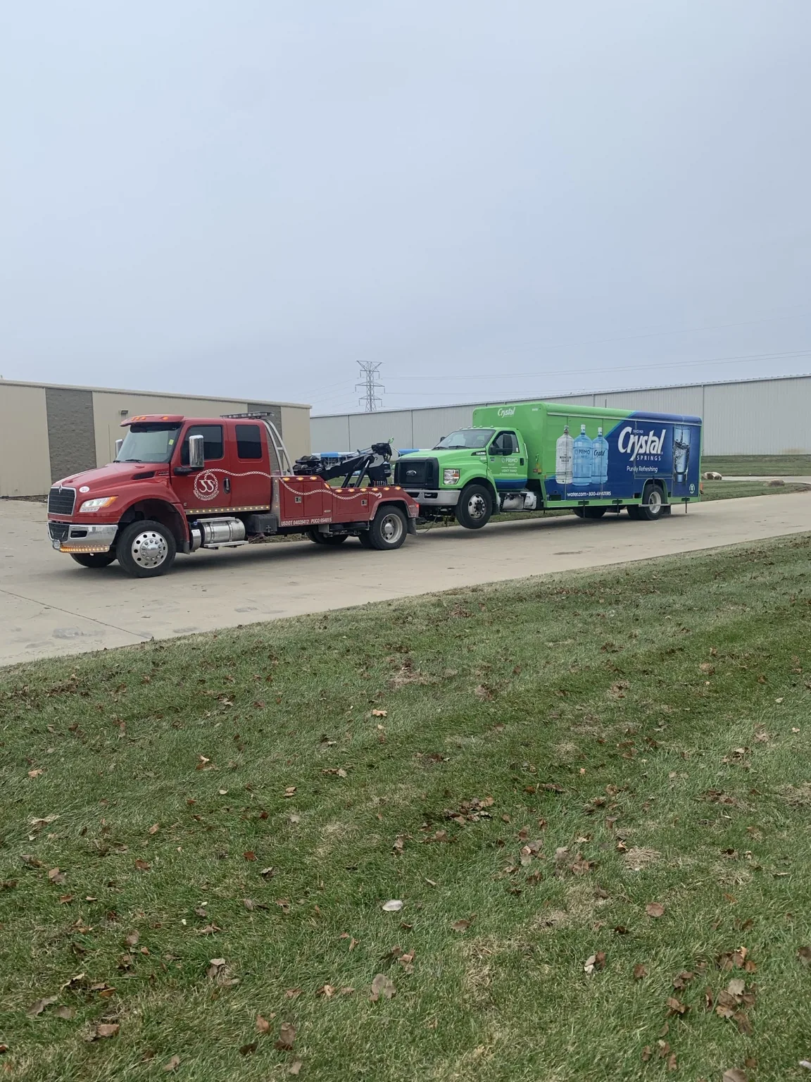 JJ’s red tow truck with a commercial truck
