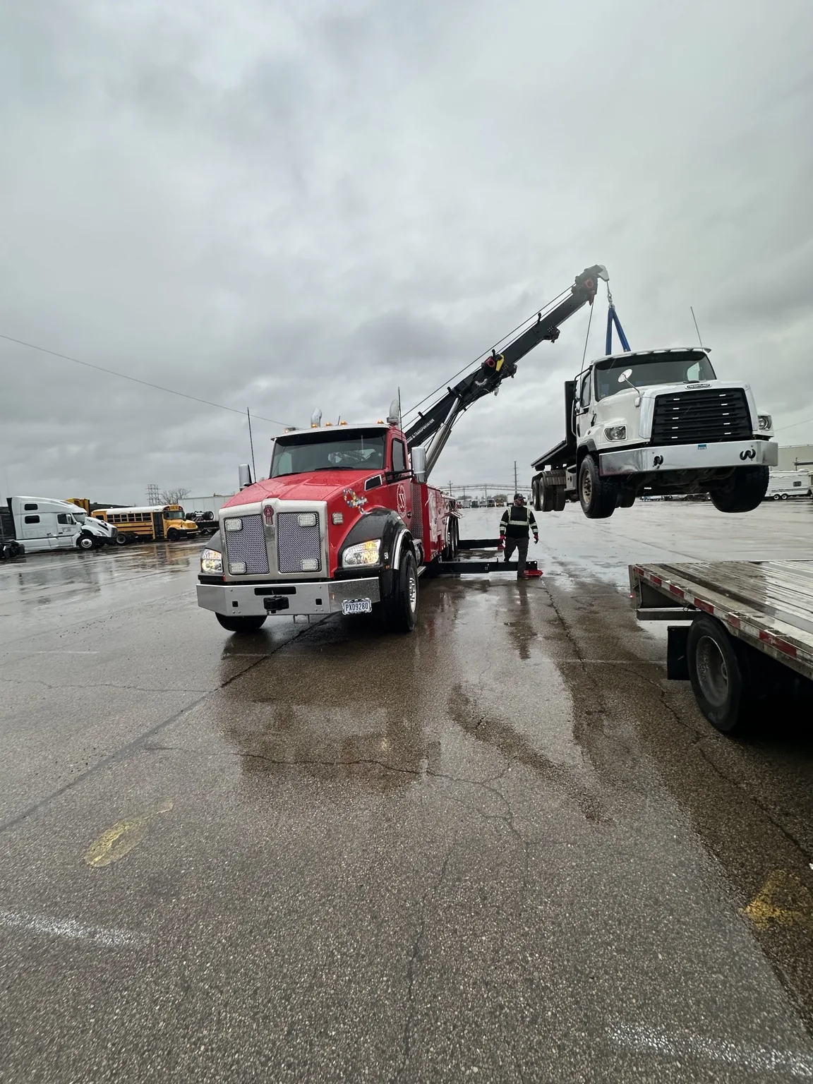 JJ’s red heavy duty wrecker lifting a white truck