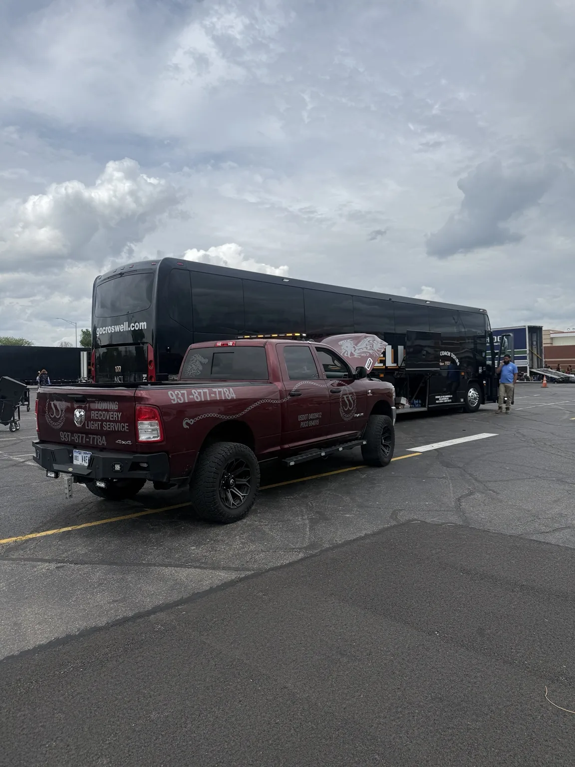 JJ’s support truck parked beside a coach bus