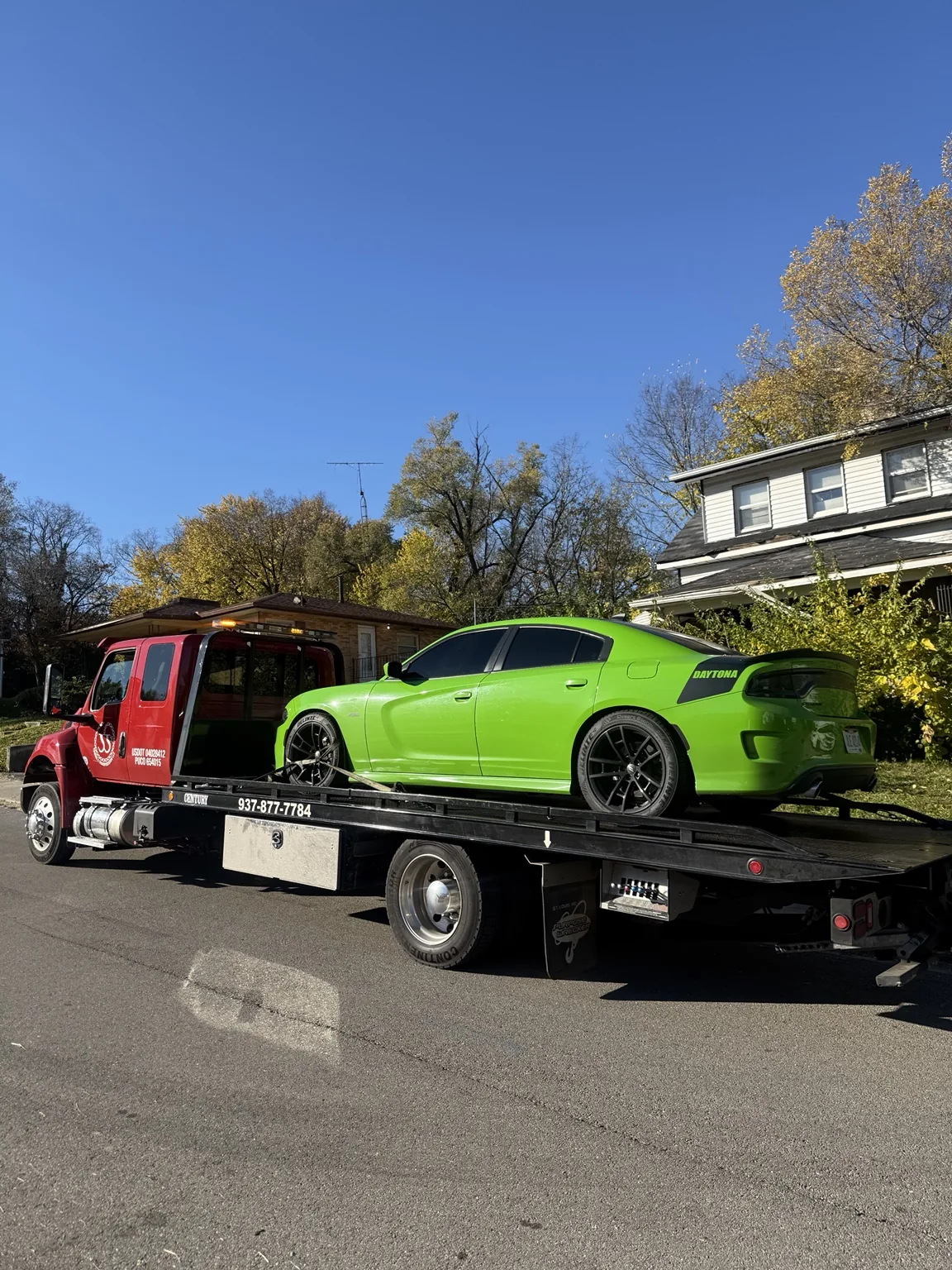 JJ’s flatbed transporting a green passenger car